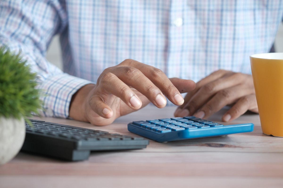 An accountant's desk with a calculator, notebook, and financial reports